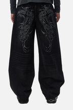 Men's black wide-leg jeans with graphic back pockets and gathered hems