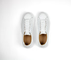 White low-top leather sneakers with laces and thick flat soles