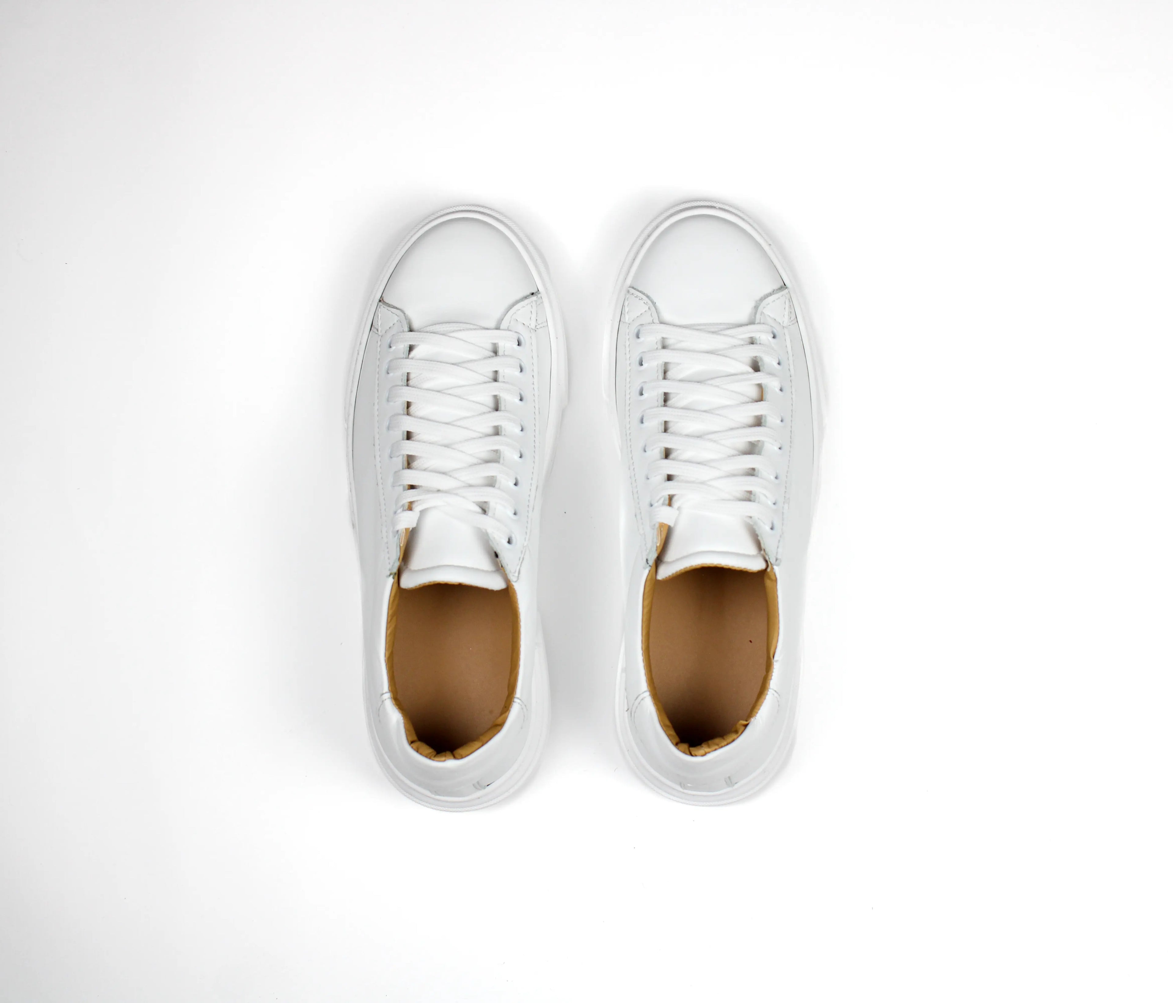White low-top leather sneakers with laces and thick flat soles