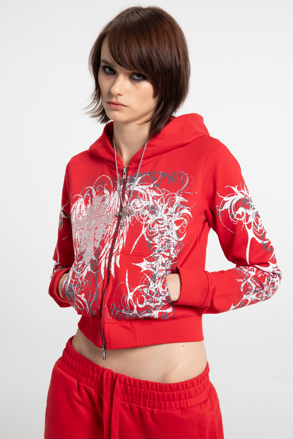 Women's red cropped hoodie with white and grey graphic print, hood and zip front