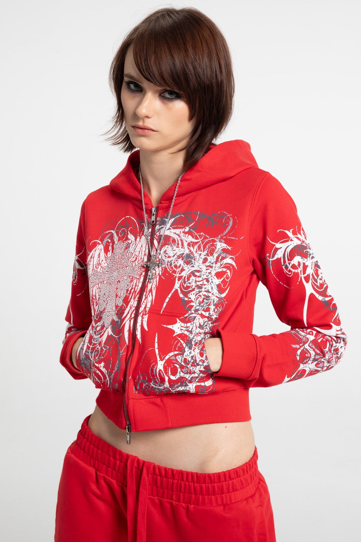 Women's red cropped hoodie with white and grey graphic print, hood and zip front
