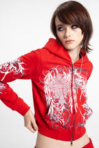Women's red cropped hoodie with white and grey graphic print, hood and zip front