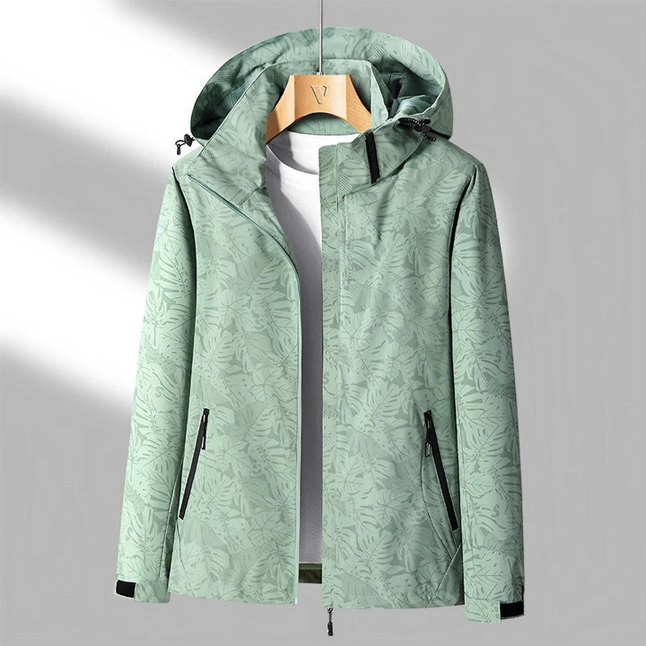 Women's hooded leaf pattern rain jacket with long sleeves and zipped pockets