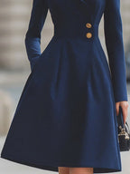 Women's navy tailored coat dress with peak lapels and gold-tone buttons