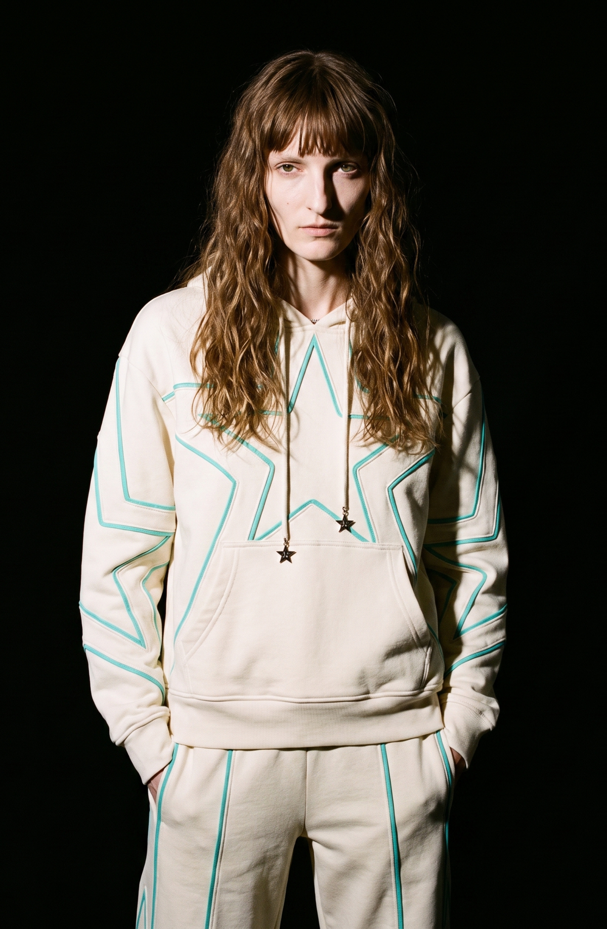 Cream hoodie with turquoise outlined star pattern, drawstring hood and front pouch pocket