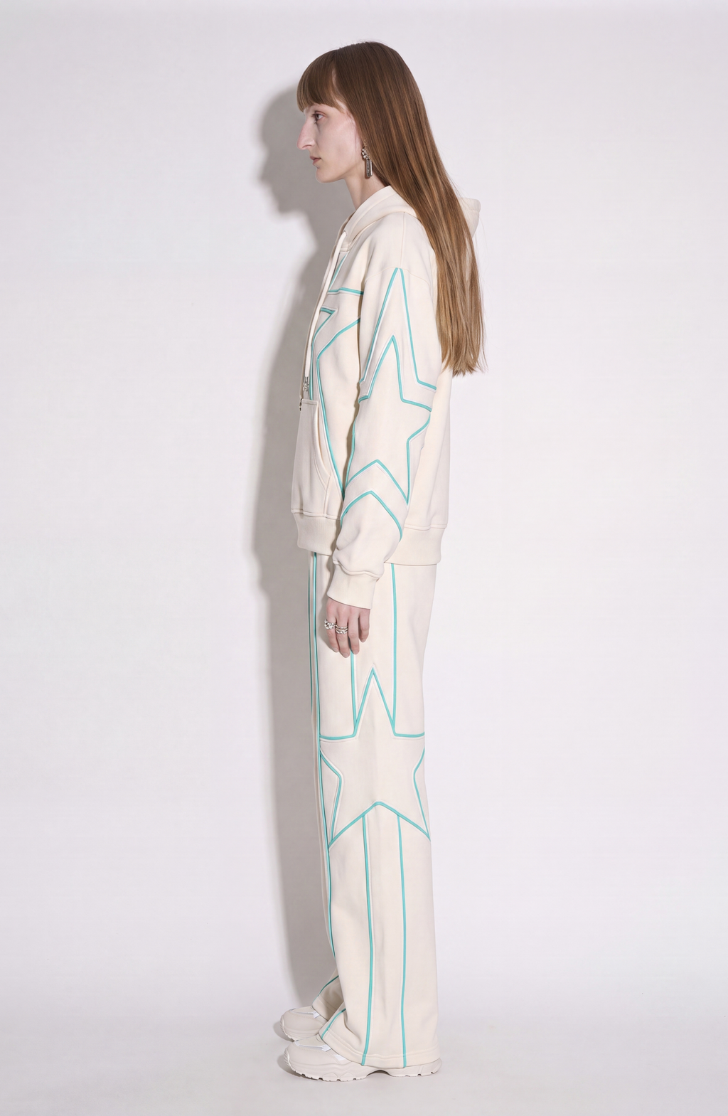 Cream hoodie with turquoise outlined star pattern, drawstring hood and front pouch pocket