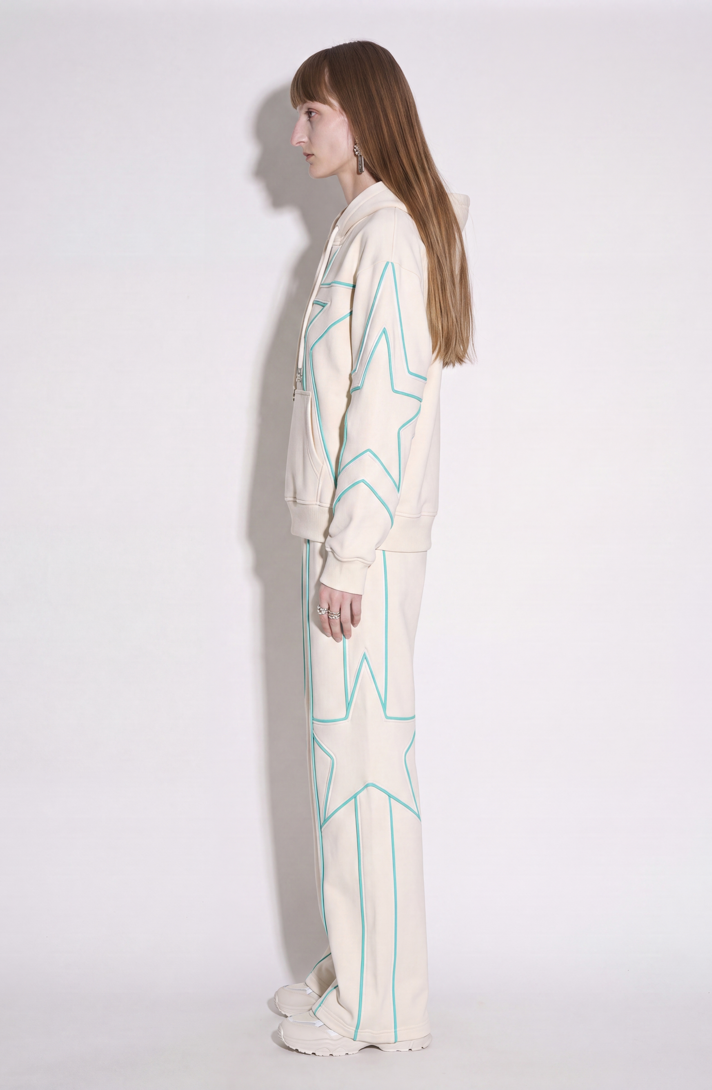 Cream hoodie with turquoise outlined star pattern, drawstring hood and front pouch pocket