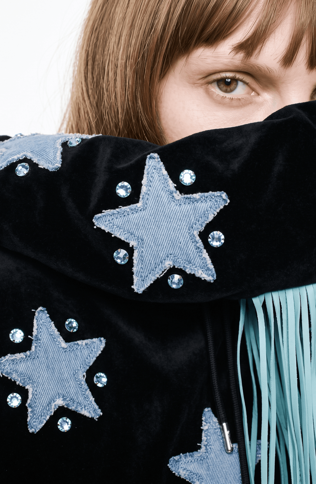 Black velvet hoodie with blue star appliqués and turquoise hood fringe
