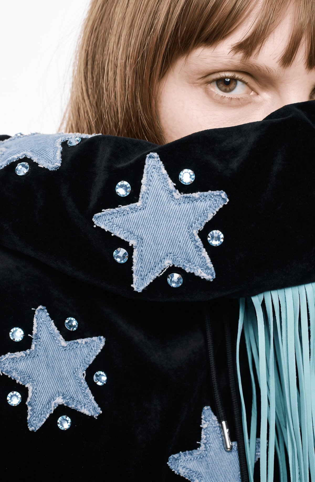 Black velvet hoodie with blue star appliqués and turquoise hood fringe