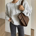 Women's knitted cardigan with round neckline, long sleeves and button front