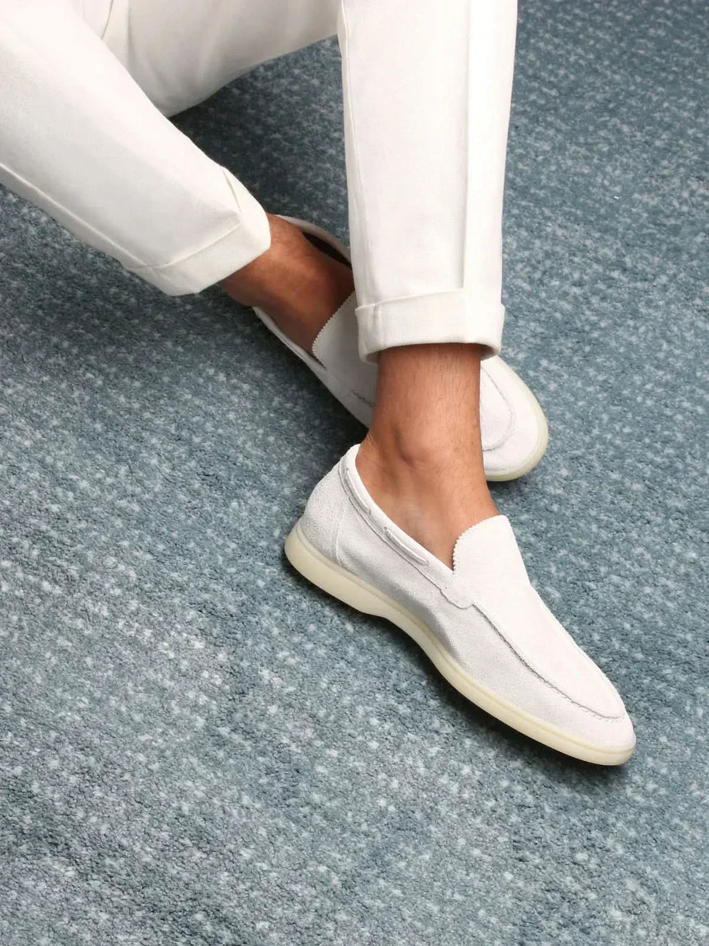Men's white slip-on loafers with stitched detailing and flat soles