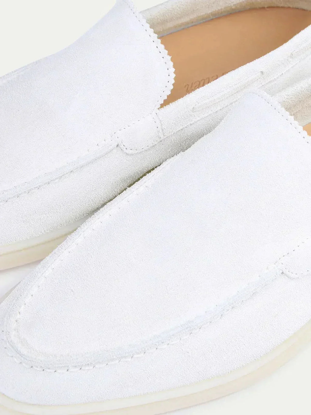 Men's white slip-on loafers with stitched detailing and flat soles