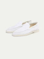 Men's white slip-on loafers with stitched detailing and flat soles