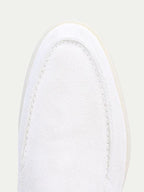 Men's white slip-on loafers with stitched detailing and flat soles
