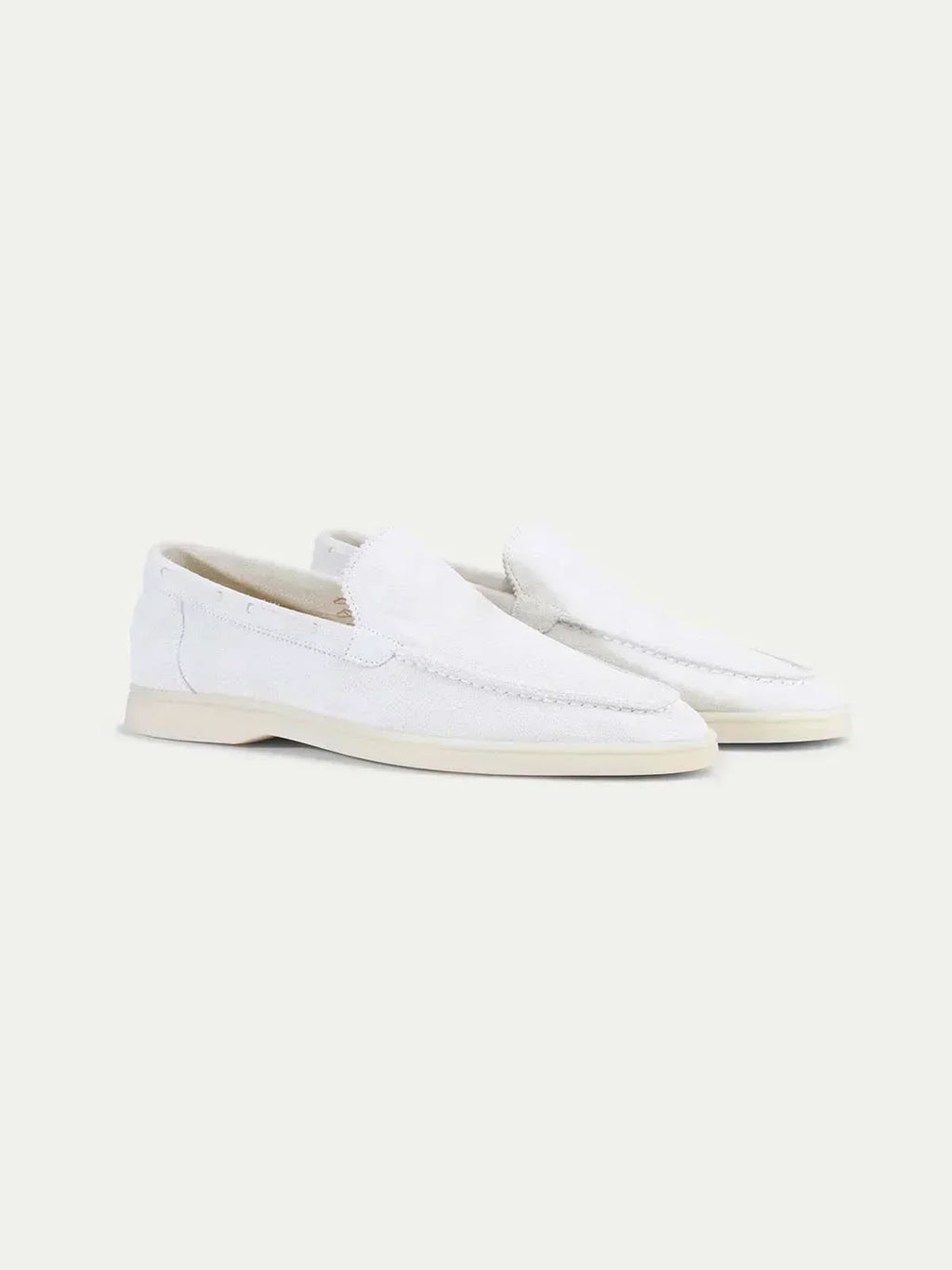 Men's white slip-on loafers with stitched detailing and flat soles