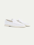 Men's white slip-on loafers with stitched detailing and flat soles