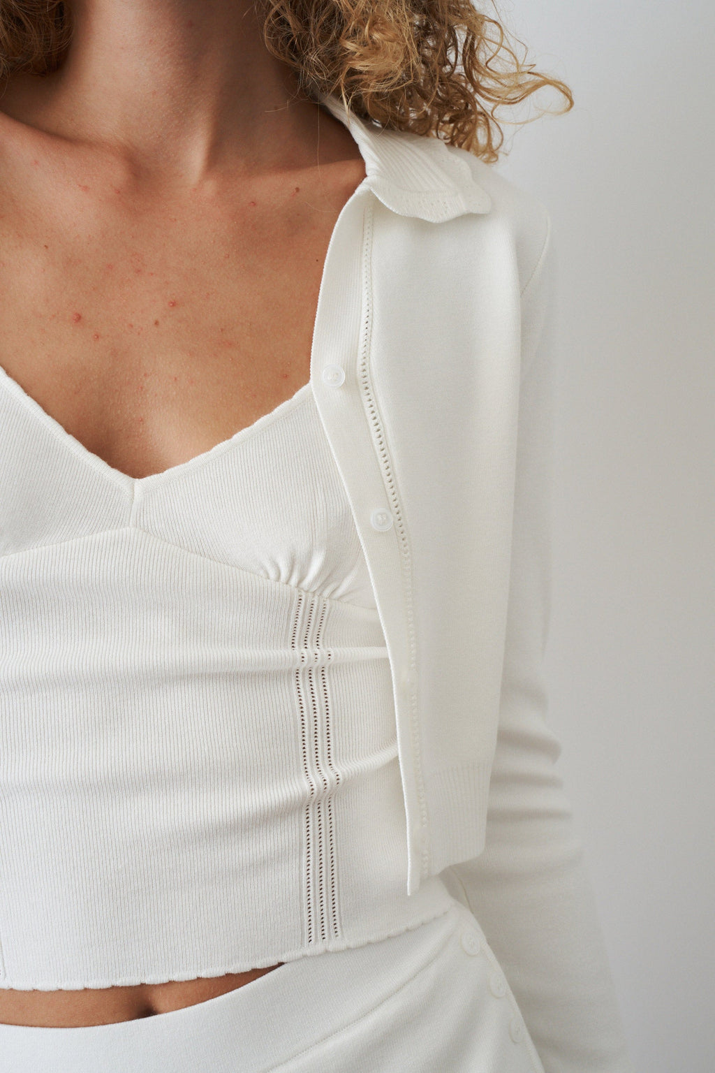 Women's white cropped cardigan with collar, buttons and long sleeves