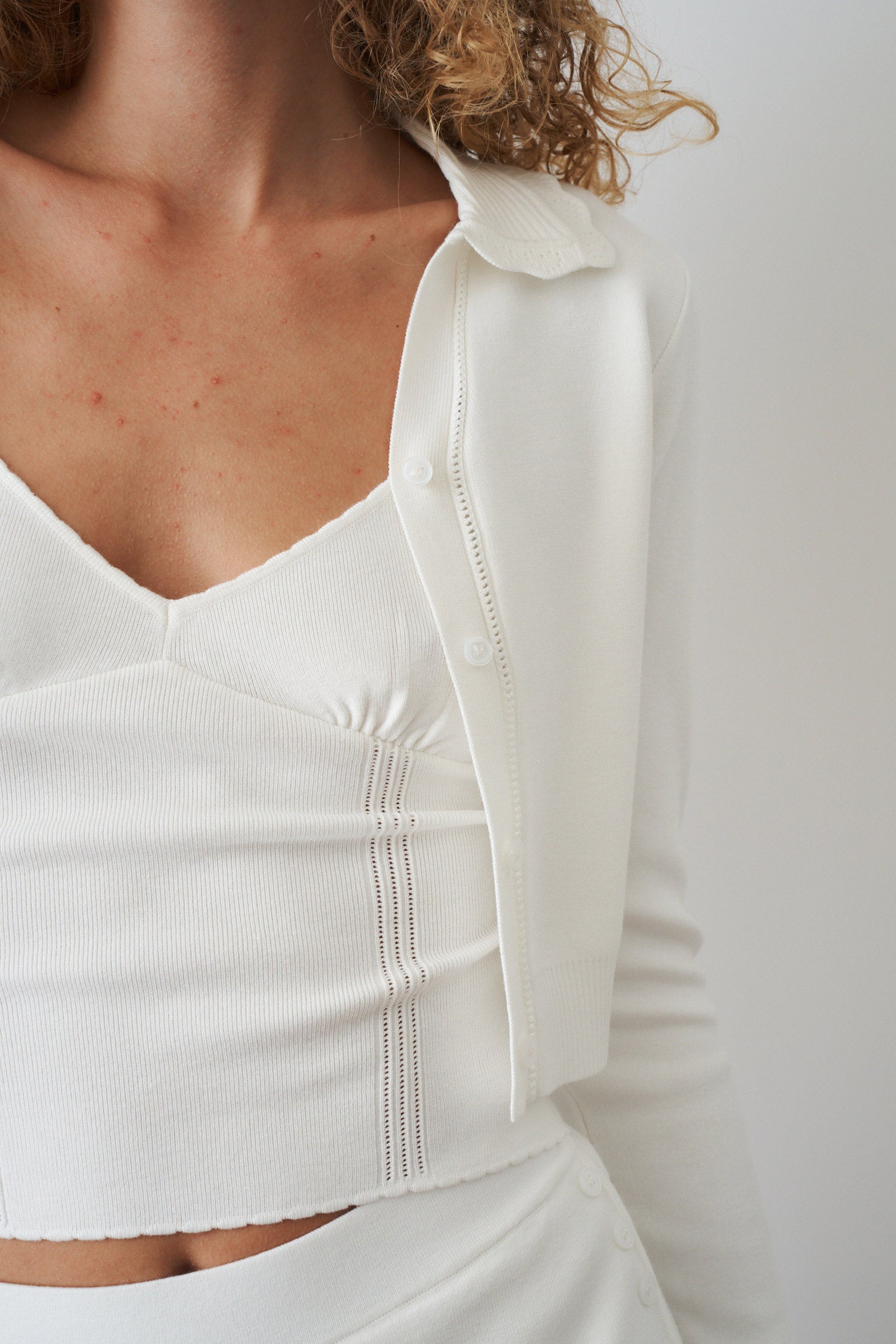 Women's white cropped cardigan with collar, buttons and long sleeves