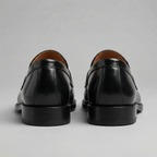 Black men's penny loafers with rounded moc toes and low heels