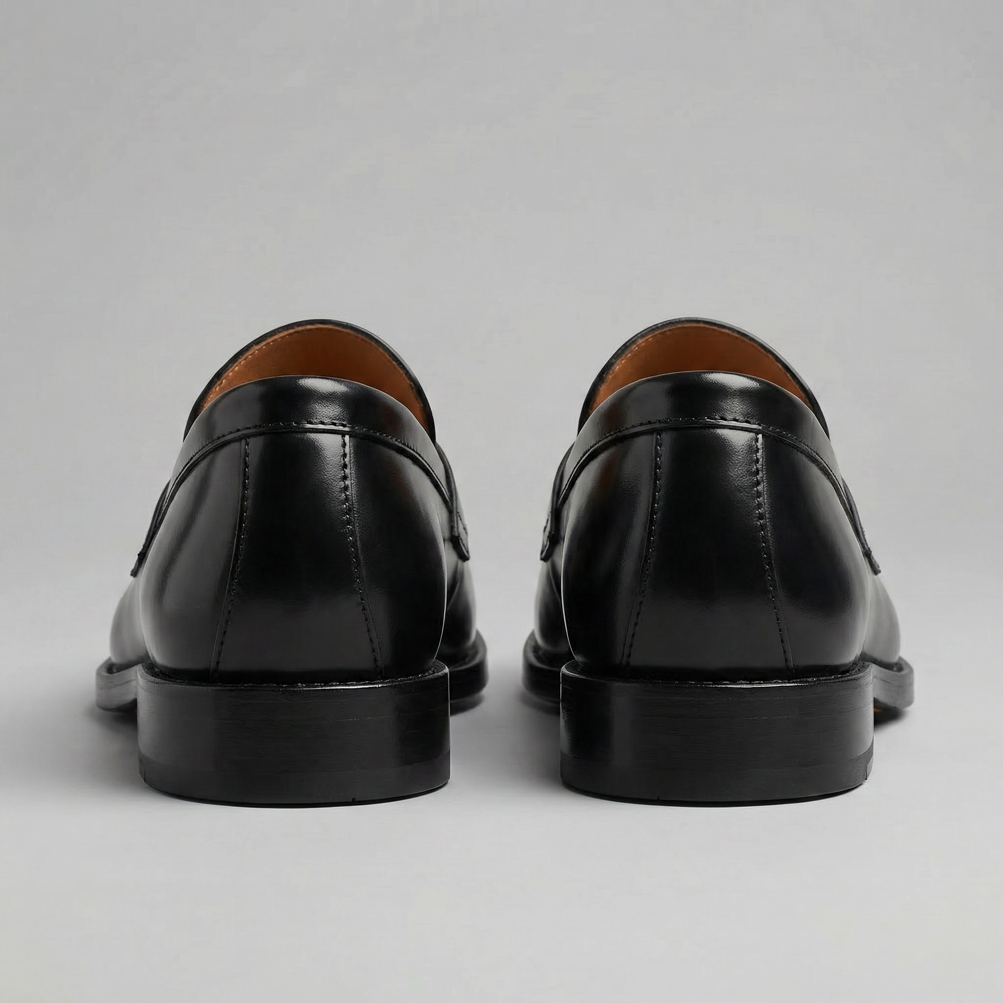 Black men's penny loafers with rounded moc toes and low heels