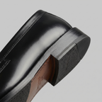 Black men's penny loafers with rounded moc toes and low heels