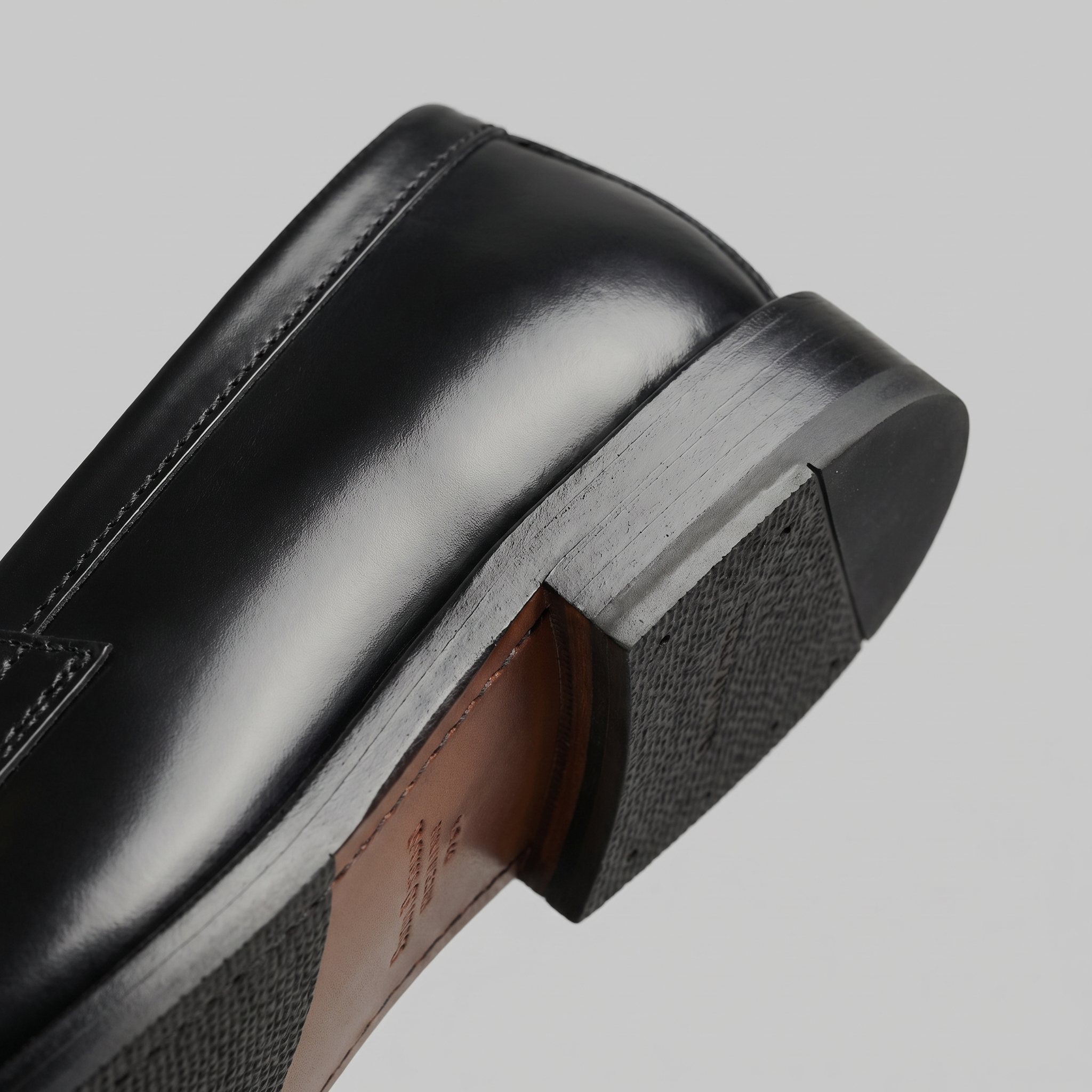Black men's penny loafers with rounded moc toes and low heels