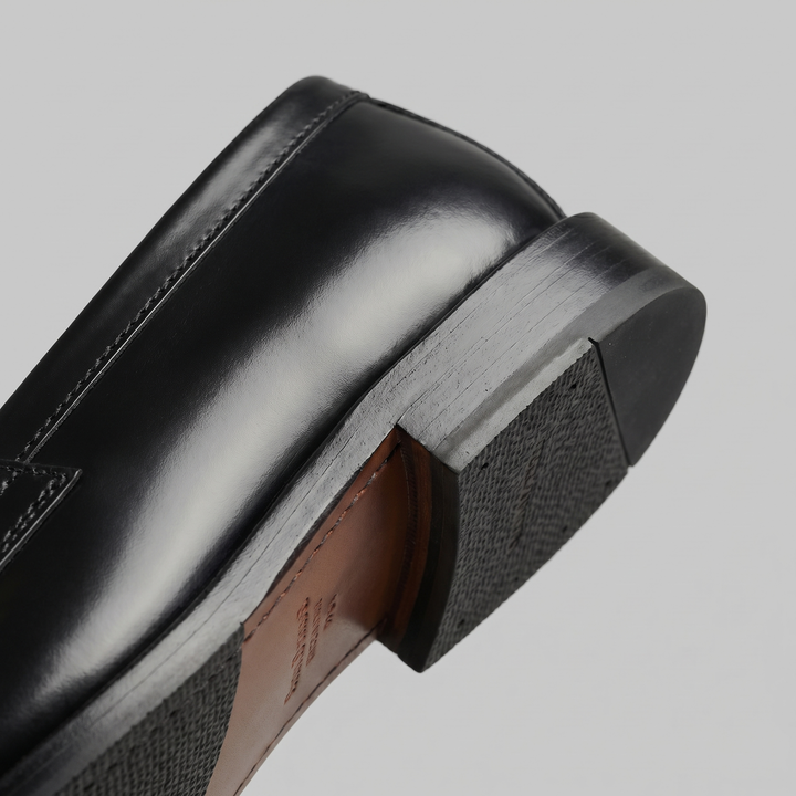 Black men's penny loafers with rounded moc toes and low heels