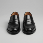 Black men's penny loafers with rounded moc toes and low heels