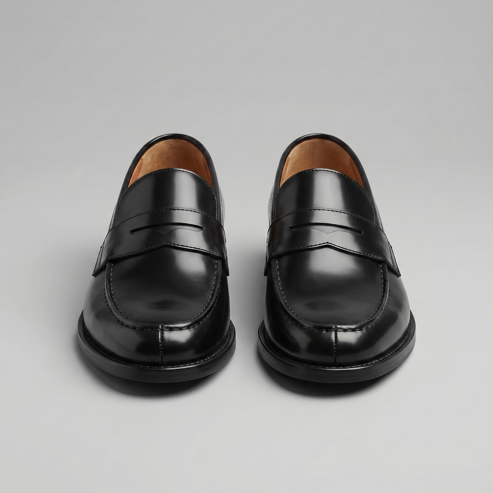 Black men's penny loafers with rounded moc toes and low heels
