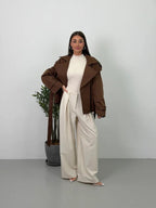 Women's brown cropped trench coat with wide lapels and tie belt