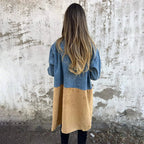 Women's mid-length trench coat with contrasting denim-look sleeves, lapel collar and button front