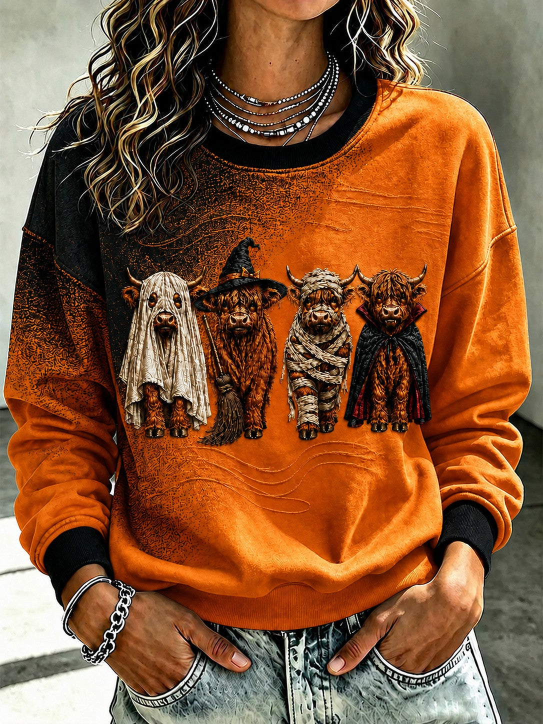Women's orange Halloween sweatshirt with four costumed Highland cattle graphic