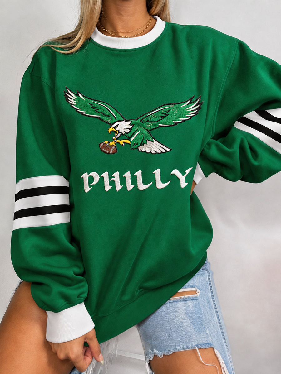 Women's green sweatshirt with eagle football graphic and striped sleeves