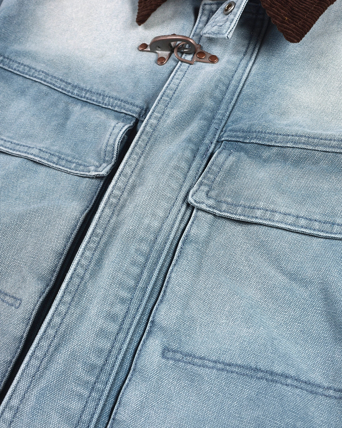 Blue boxy denim jacket with dark corduroy collar, long sleeves and multiple front pockets