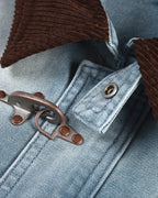 Blue boxy denim jacket with dark corduroy collar, long sleeves and multiple front pockets