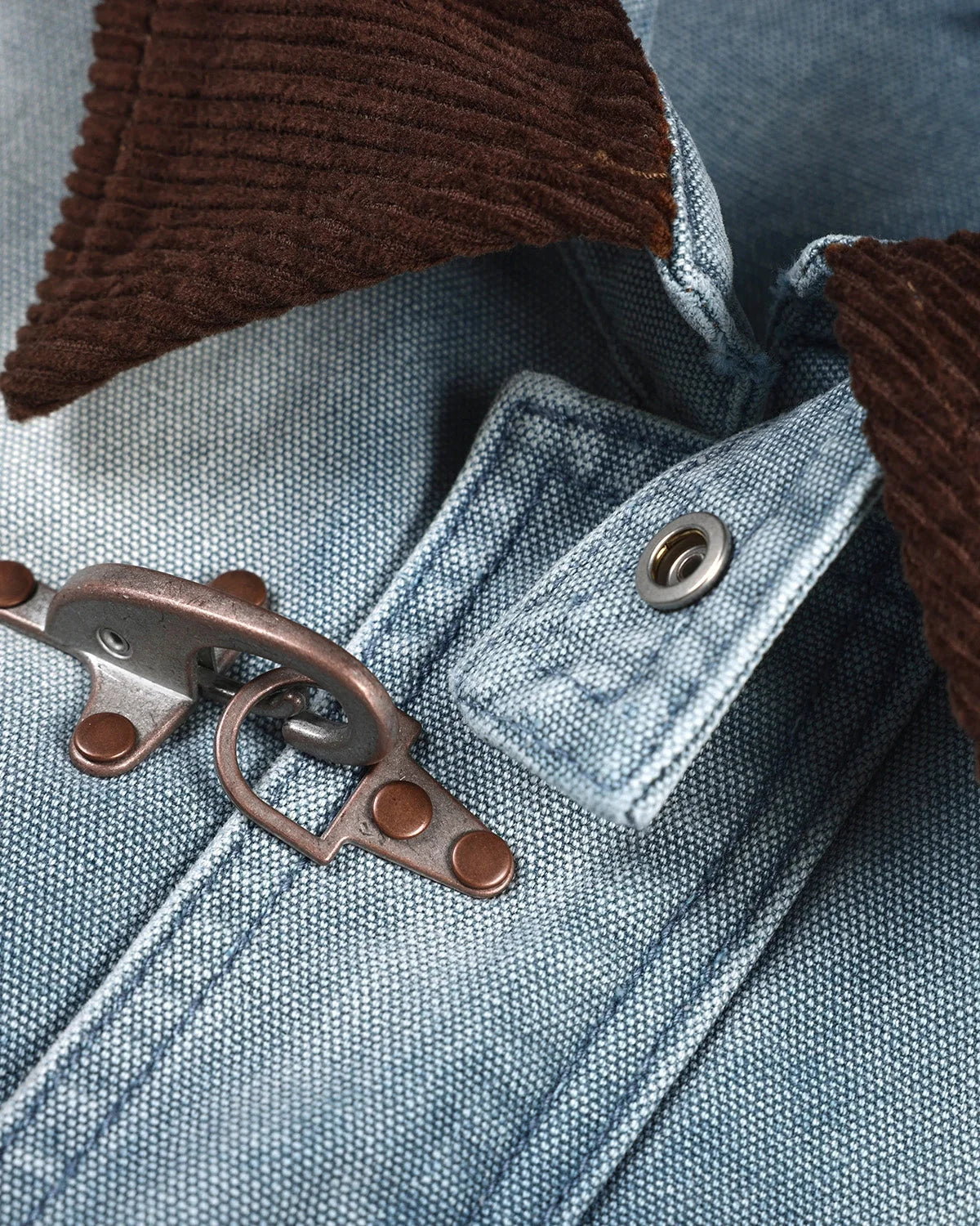 Blue boxy denim jacket with dark corduroy collar, long sleeves and multiple front pockets