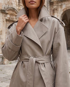 Women's oversized short belted trench jacket with wide lapels and long sleeves