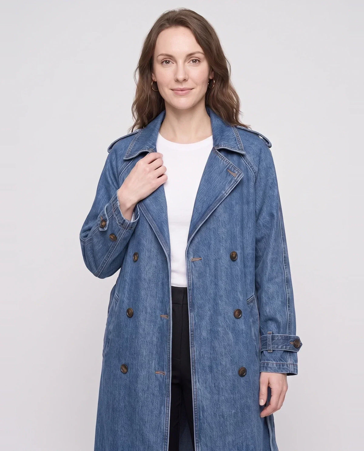 Women's long denim trench coat with lapels, buttons, belt and cuff straps