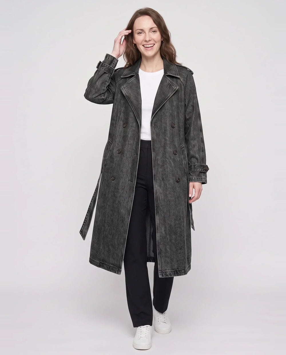 Women's long denim trench coat with lapels, buttons, belt and cuff straps