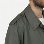 Men's muted green long raincoat with button front, pointed collar and shoulder tabs