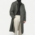 Men's muted green long raincoat with button front, pointed collar and shoulder tabs