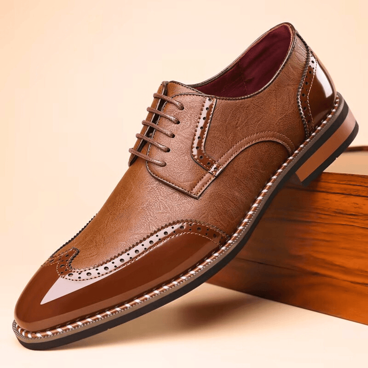 Men's brogue dress shoe with pointed toe, lace-up front and perforated panels