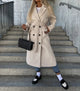 Women's long double-breasted belted coat with notched lapels and flap pockets