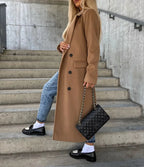 Women's long double-breasted belted coat with notched lapels and flap pockets